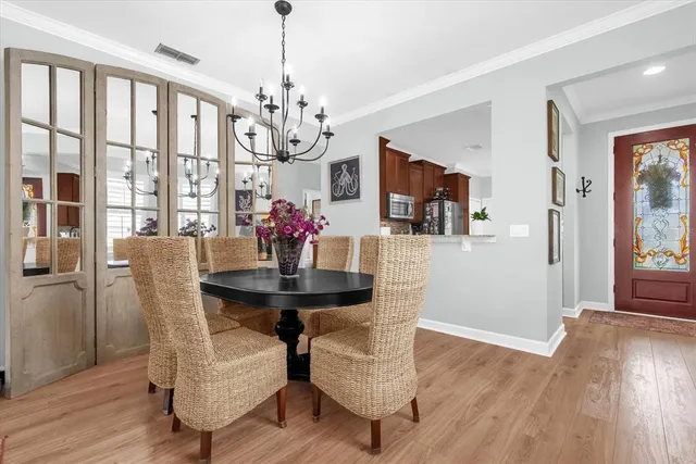 a view of a dining room with furniture a chandelier and wooden floor