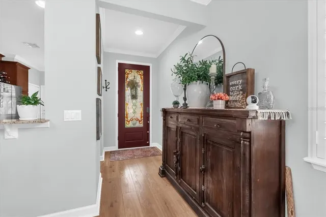 a hallway with a stove a mirror and a potted plant
