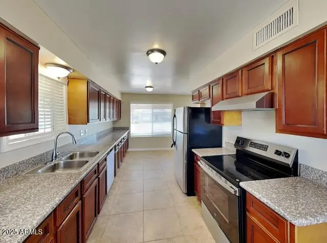 a kitchen with stainless steel appliances granite countertop a sink stove and refrigerator
