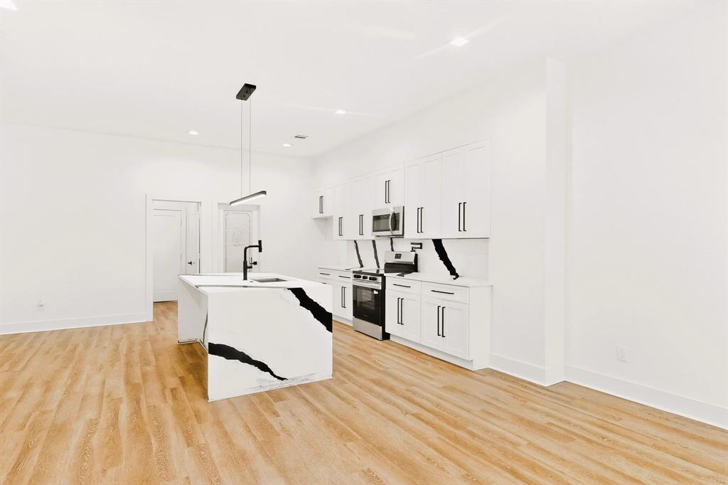 1218 Grant Street Dallas, TX 75203 - Photo 13 of 40 a large white kitchen with wooden floor