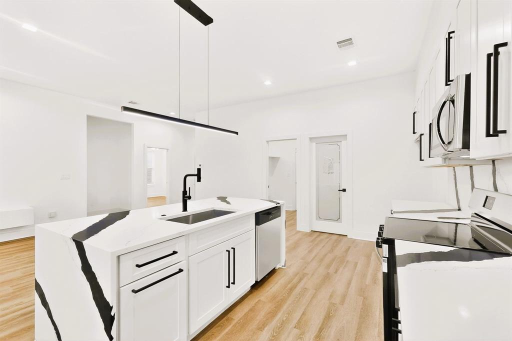1218 Grant Street Dallas, TX 75203 - Photo 17 of 40 a kitchen with a sink and a refrigerator
