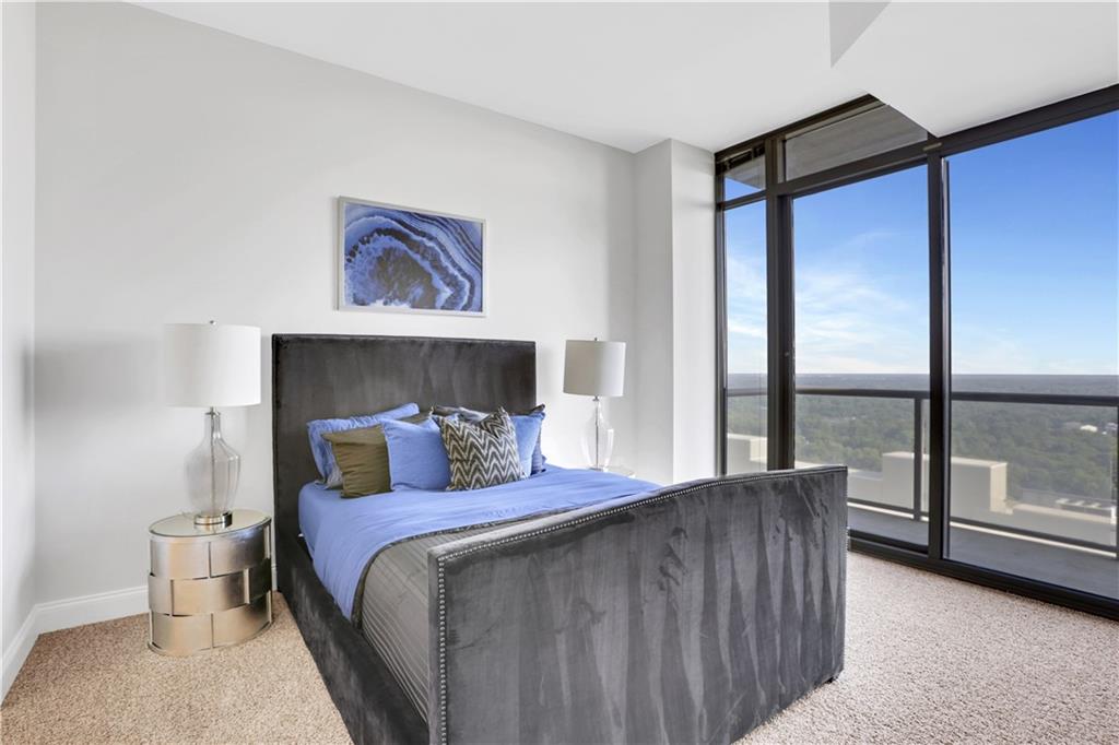 270 17th Street Northwest, Unit 3308 Atlanta, GA 30363 - Photo 12 of 49 a bedroom with a large bed and a balcony