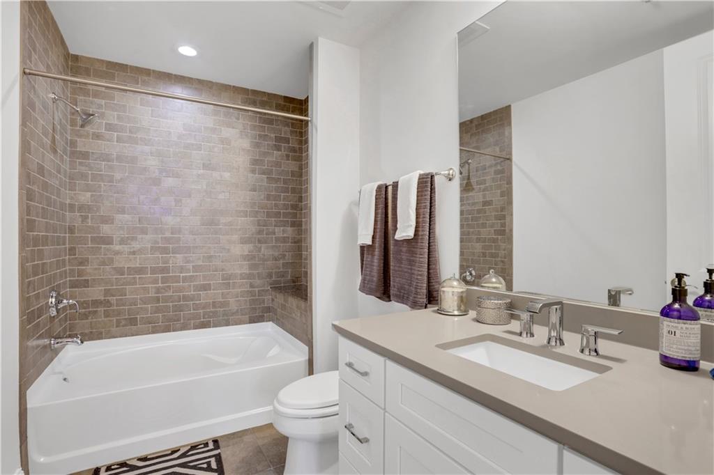 270 17th Street Northwest, Unit 3308 Atlanta, GA 30363 - Photo 15 of 49 a bathroom with a granite countertop bathtub shower sink vanity and toilet