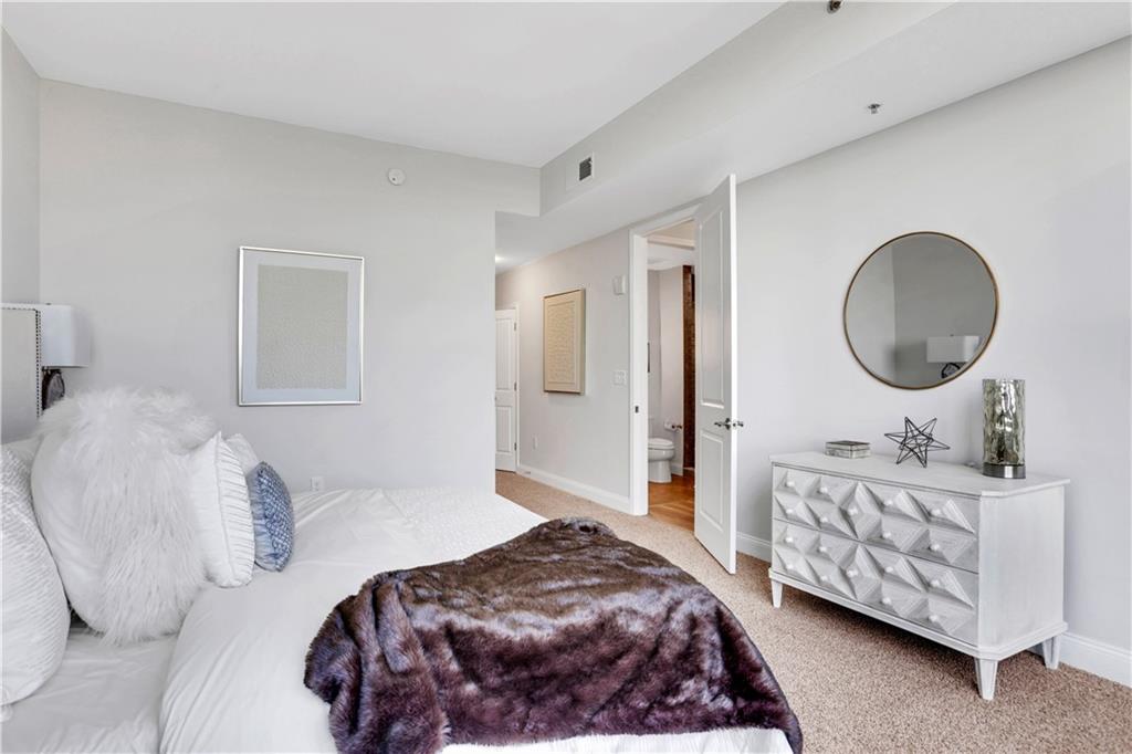 270 17th Street Northwest, Unit 3308 Atlanta, GA 30363 - Photo 20 of 49 a bedroom with a bed a mirror and lamp