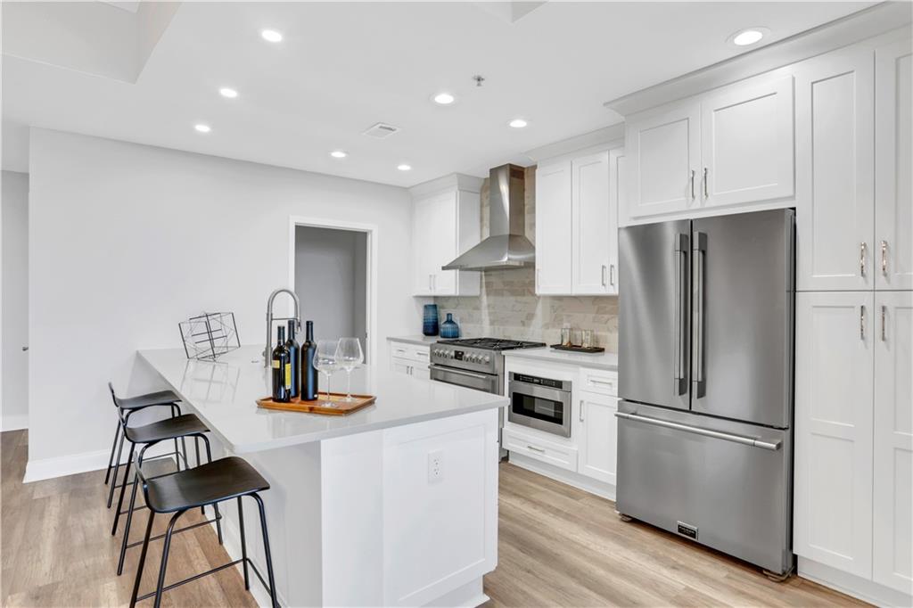 270 17th Street Northwest, Unit 3308 Atlanta, GA 30363 - Photo 6 of 49 a kitchen with kitchen island a stove a refrigerator and wooden floor