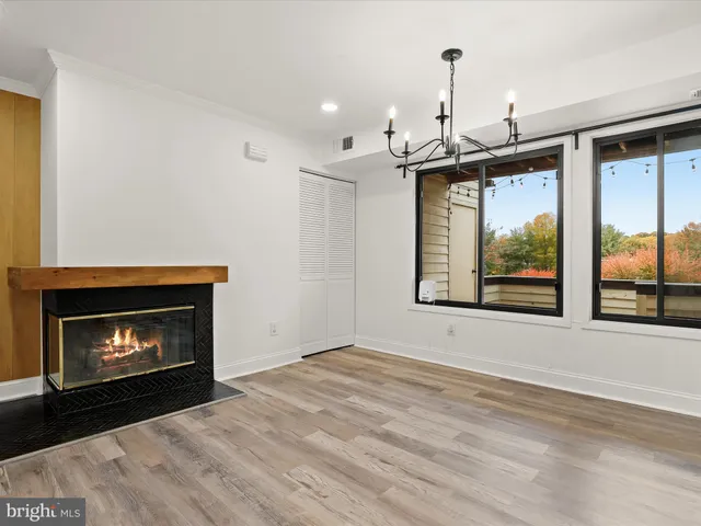 a view of an empty room with a fireplace and window