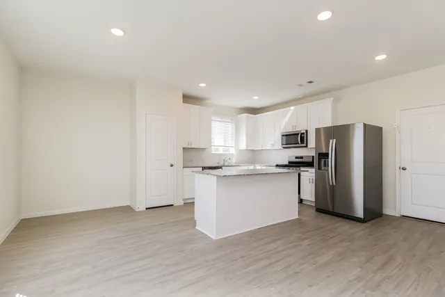 a kitchen with a refrigerator sink and cabinets