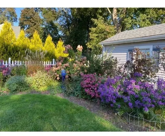 a view of a house with a big yard and fountain