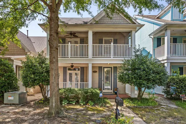 a front view of a house with a yard and potted plants