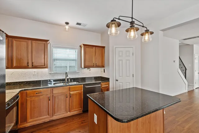 a kitchen with granite countertop a sink a stove and cabinets
