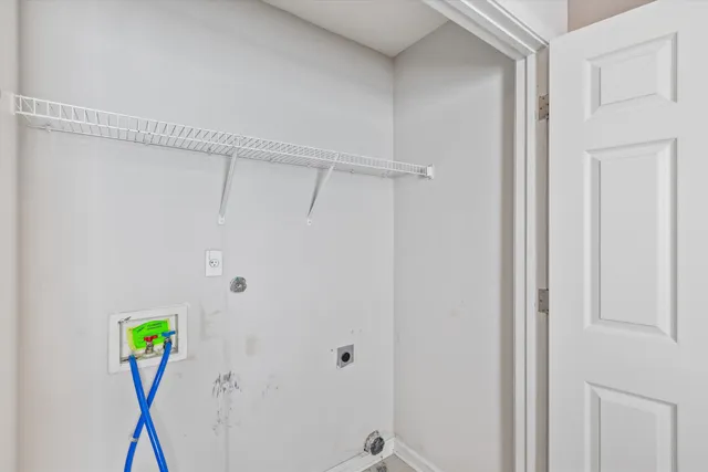 an empty room with a chandelier fan and windows