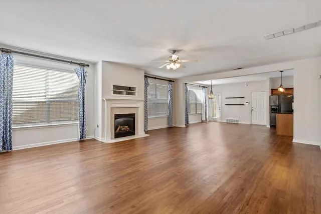 a view of a livingroom with wooden floor and a kitchen