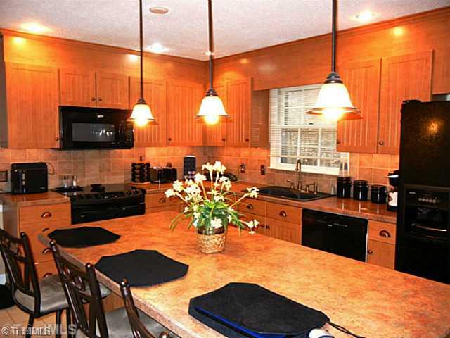 1411 Chesterfield Road Lewisville, NC 27023 - Photo 3 of 16 Kitchen. Look at this remodeled kitchen.....you should see the before and after photos! Well, everything was new 3 years ago, cabinets, counters, island, appliances, sink, fixture and island lights and under the counter lights.