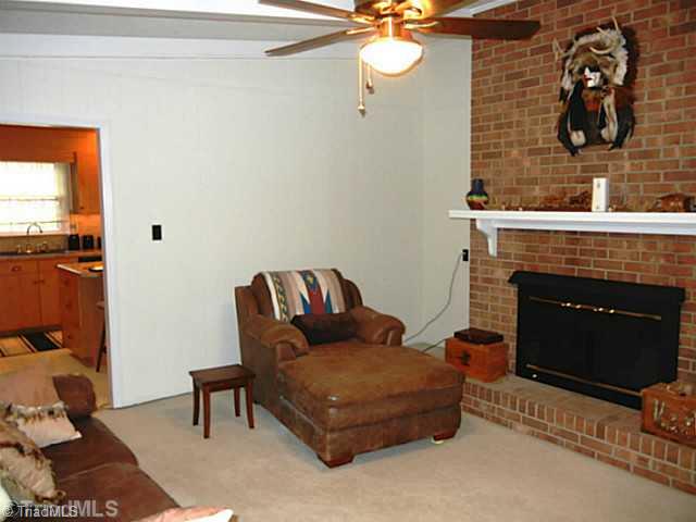 1411 Chesterfield Road Lewisville, NC 27023 - Photo 5 of 16 Den/Family/Great Room. Main level den off the kitchen with vaulted ceiling, a brick fireplace with gas logs, FP screen and a ceiling fan. There is a door in this room that leads to a walk up attic space.