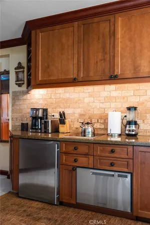 a kitchen with stainless steel appliances granite countertop wooden cabinets a dining table and chairs