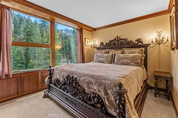 a large bed sitting in a bedroom next to a window