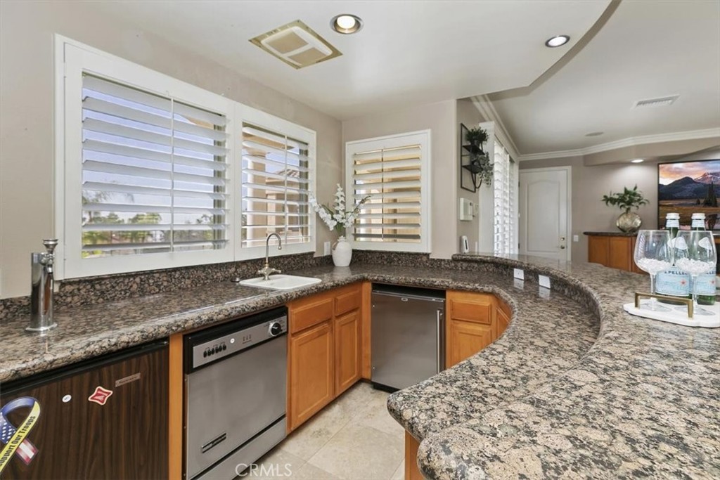5030 Calypso Court Rancho Cucamonga, CA 91737 - Photo 27 of 74 a kitchen with granite countertop sink stove and cabinets