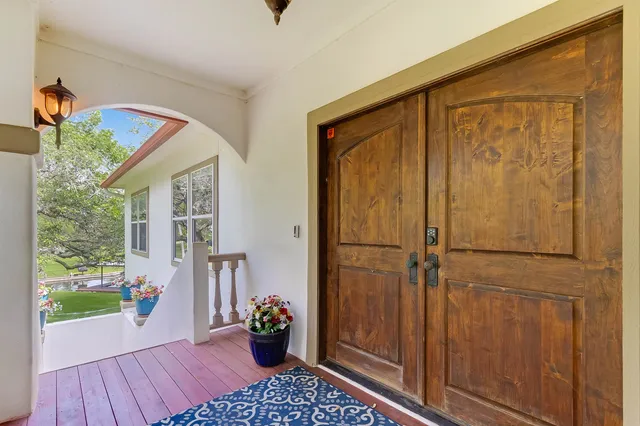 a view of a porch with wooden floor and front door