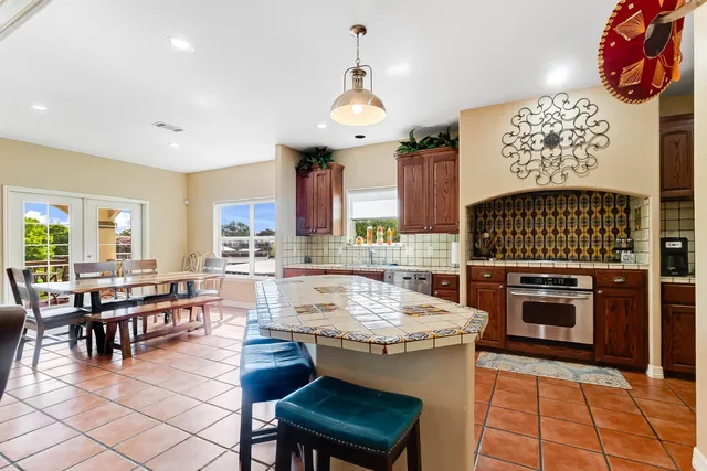 a large kitchen with kitchen island a stove a sink a dining table and chairs