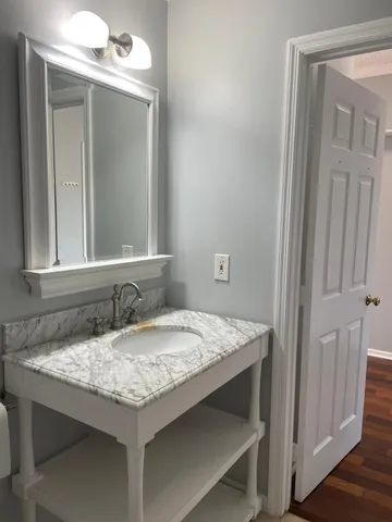 a bathroom with a granite countertop sink and a mirror