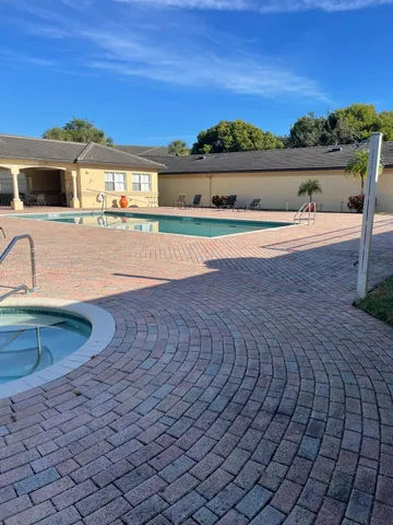 a view of swimming pool with outdoor seating and buildings in the background