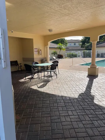 a view of a patio with dining table and chairs with a wooden floor