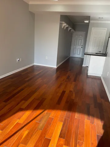 a view of an empty room with wooden floor