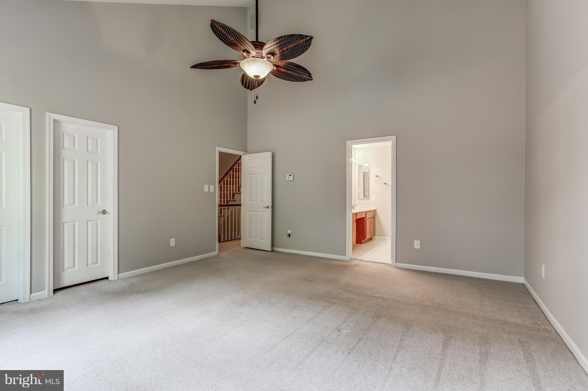 8053 Rising Ridge Road Bethesda, MD 20817 - Photo 22 of 30 an empty room with a chandelier fan and windows