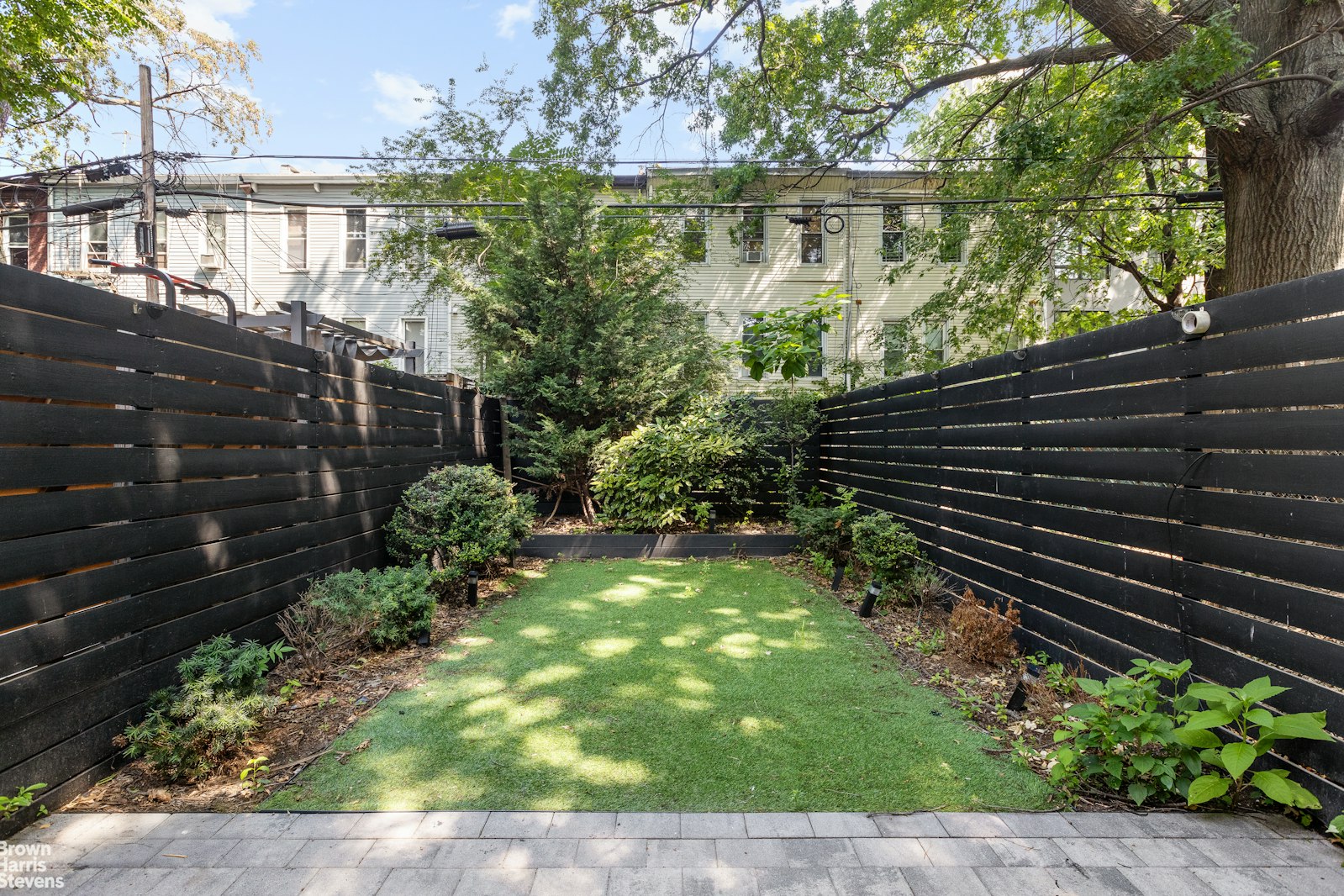 605 Decatur Street Brooklyn, NY 11233 - Photo 12 of 14 a view of a yard with plants and wooden fence