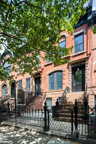a view of a yard with plants and wooden fence