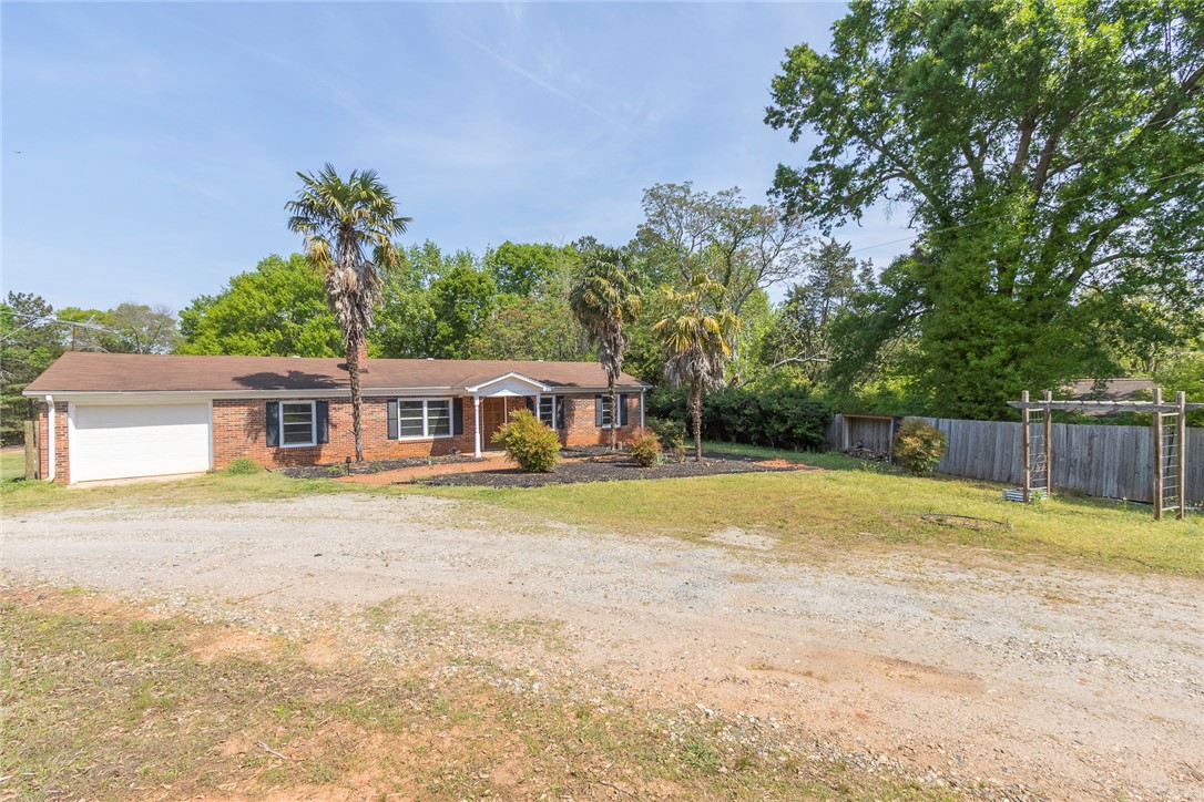820 Travis Road Anderson, SC 29626 - Photo 2 of 46 This charming home offers a spacious lot and an attached garage, nestled among lush trees.
