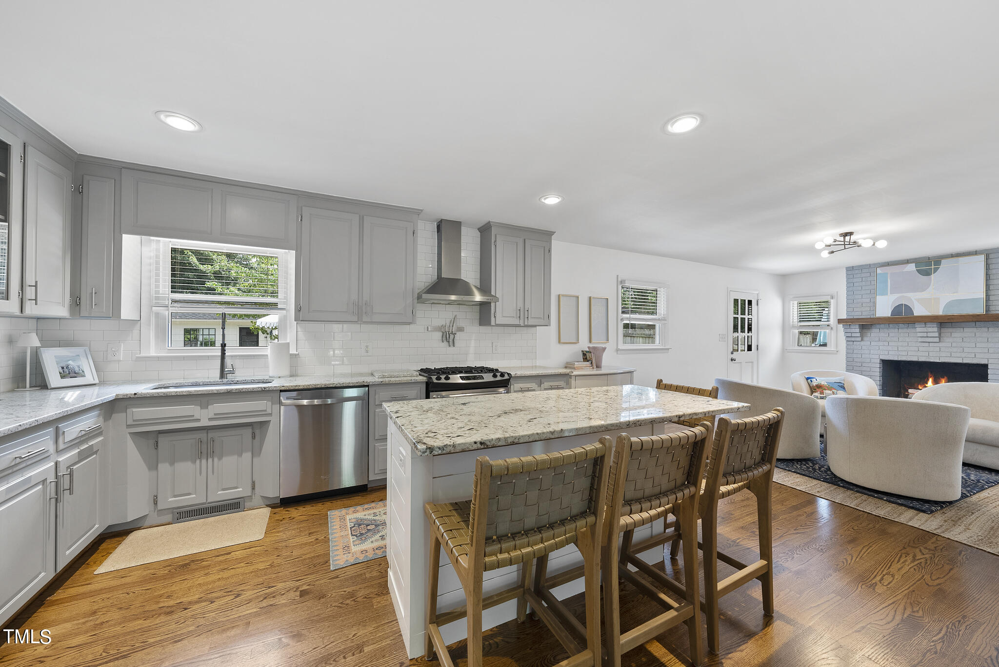 512 East Millbrook Road Raleigh, NC 27609 - Photo 4 of 29 a kitchen with kitchen island granite countertop wooden floor and stainless steel appliances