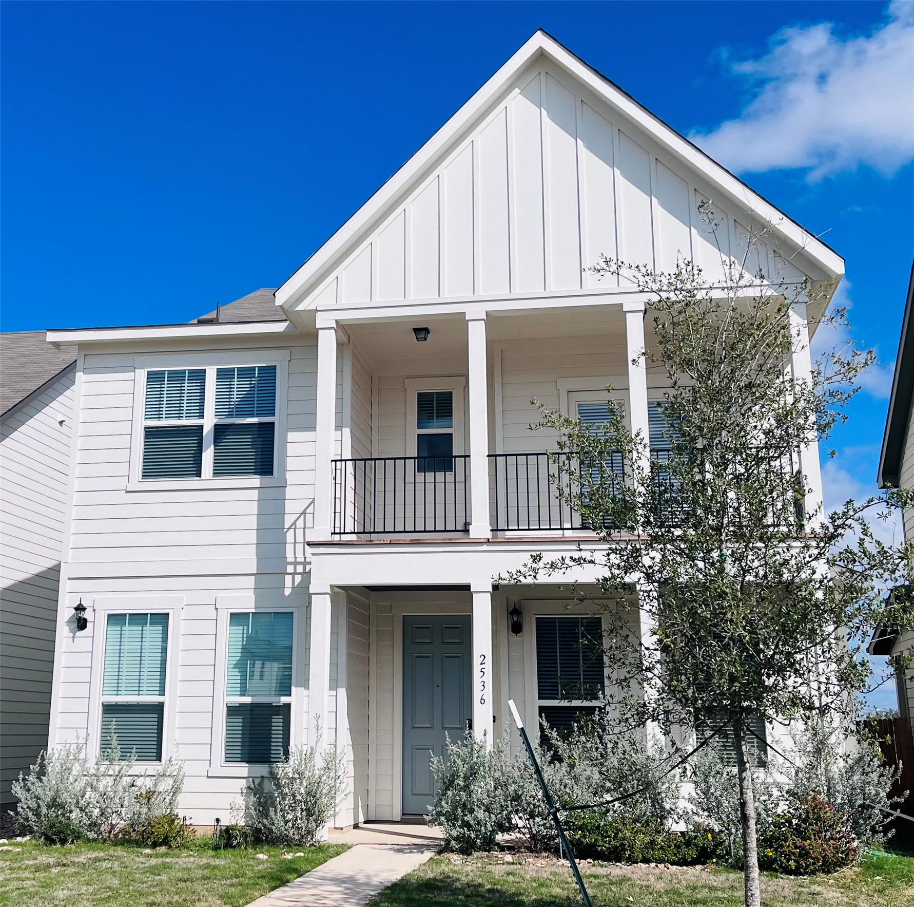 2536 Acoma Lane Leander, TX 78641 - Photo 1 of 26 View of front of property featuring board and batten siding, a balcony, and a front lawn