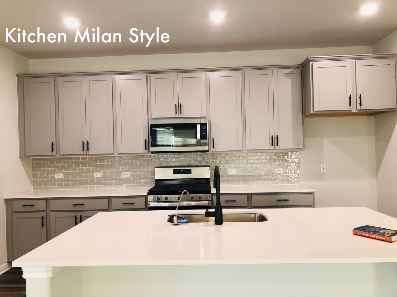 2536 Acoma Lane Leander, TX 78641 - Photo 4 of 26 Kitchen featuring stainless steel appliances, gray cabinets, an island with sink, light stone countertops, and decorative backsplash