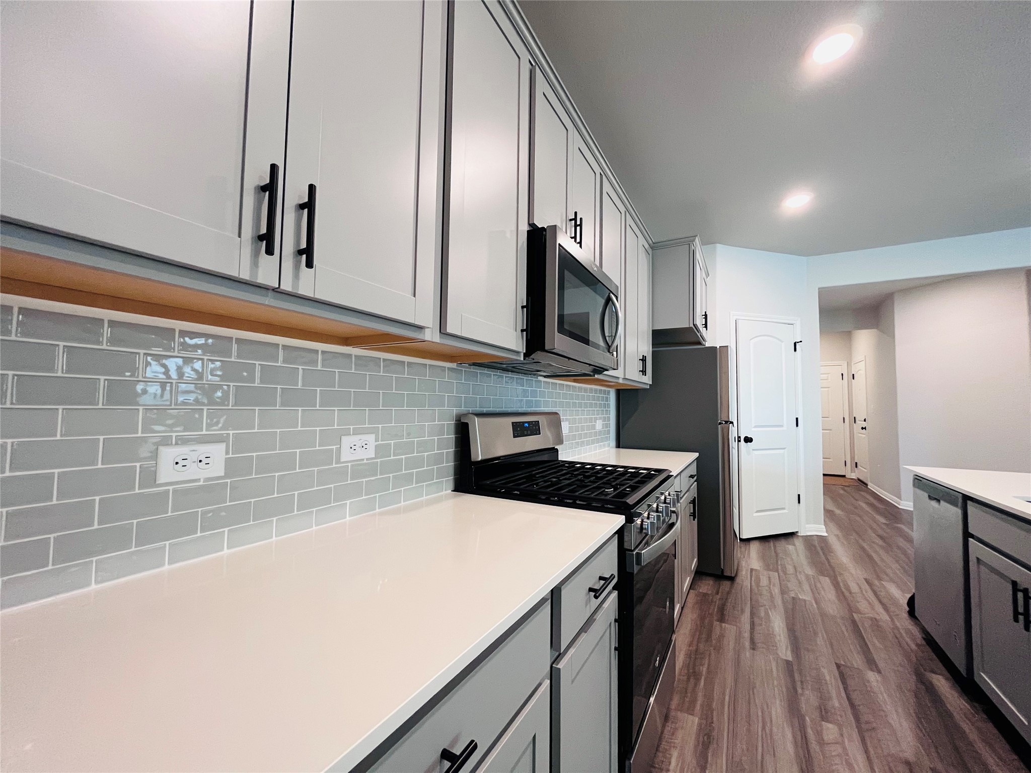 2536 Acoma Lane Leander, TX 78641 - Photo 5 of 26 Kitchen featuring stainless steel appliances, gray cabinetry, dark wood-type flooring, decorative backsplash, and recessed lighting