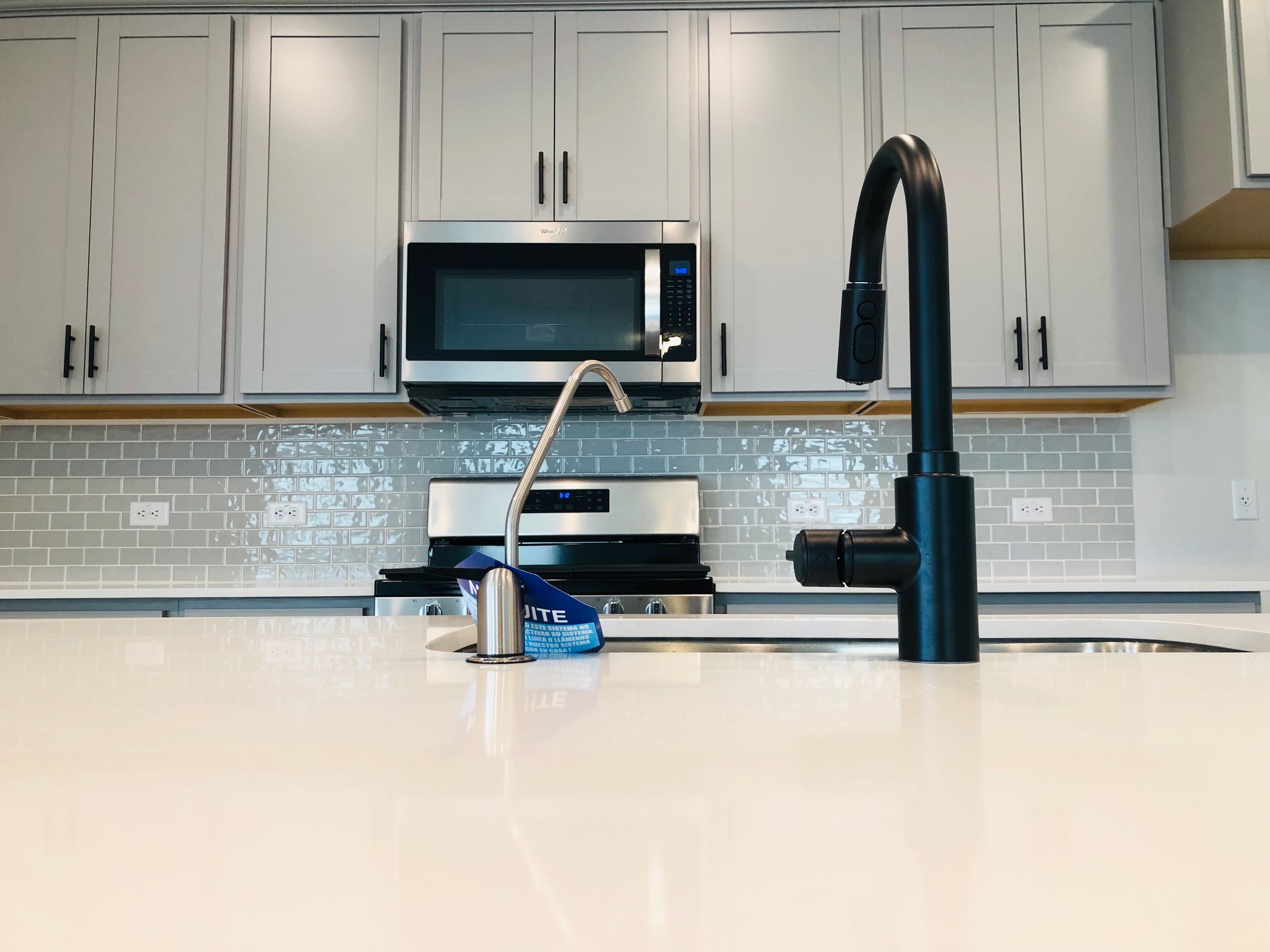 2536 Acoma Lane Leander, TX 78641 - Photo 8 of 26 Kitchen with stainless steel appliances, decorative backsplash, gray cabinetry, and light stone counters