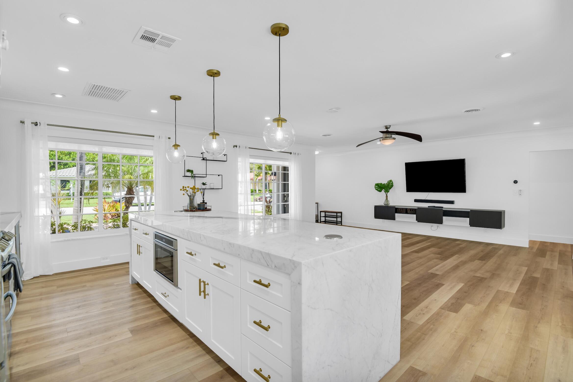 701 Appleby Street Boca Raton, FL 33487 - Photo 13 of 47 a large kitchen with stainless steel appliances kitchen island granite countertop a sink and a flat screen tv