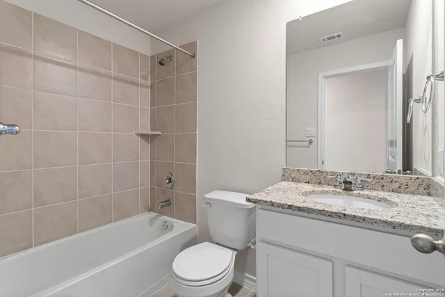 a bathroom with a granite countertop toilet a sink and bathtub