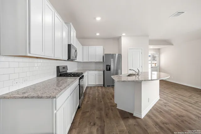 a kitchen with stainless steel appliances granite countertop wooden cabinets a sink and a stove