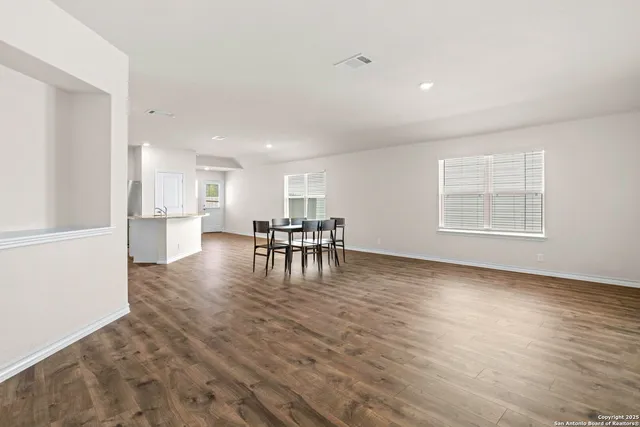 a view of empty room with wooden floor and windows