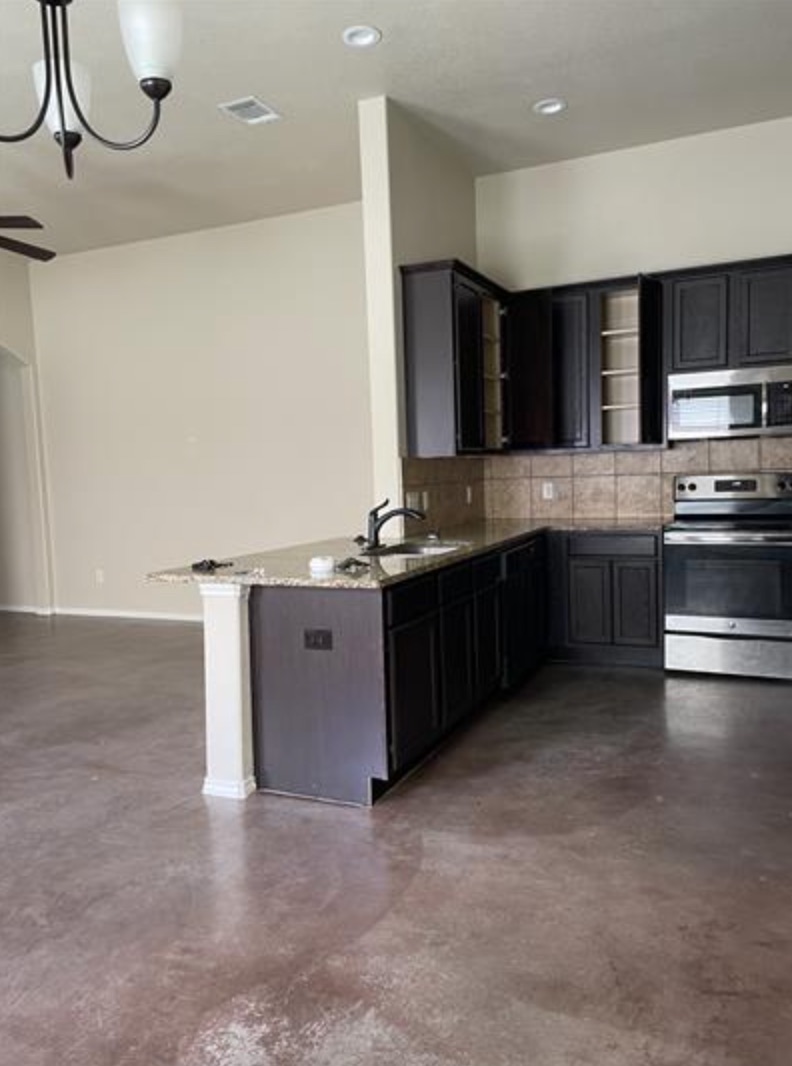 601 Jack Rabbit Lane, Unit B Buda, TX 78610 - Photo 5 of 10 a kitchen with stainless steel appliances granite countertop a sink and a stove