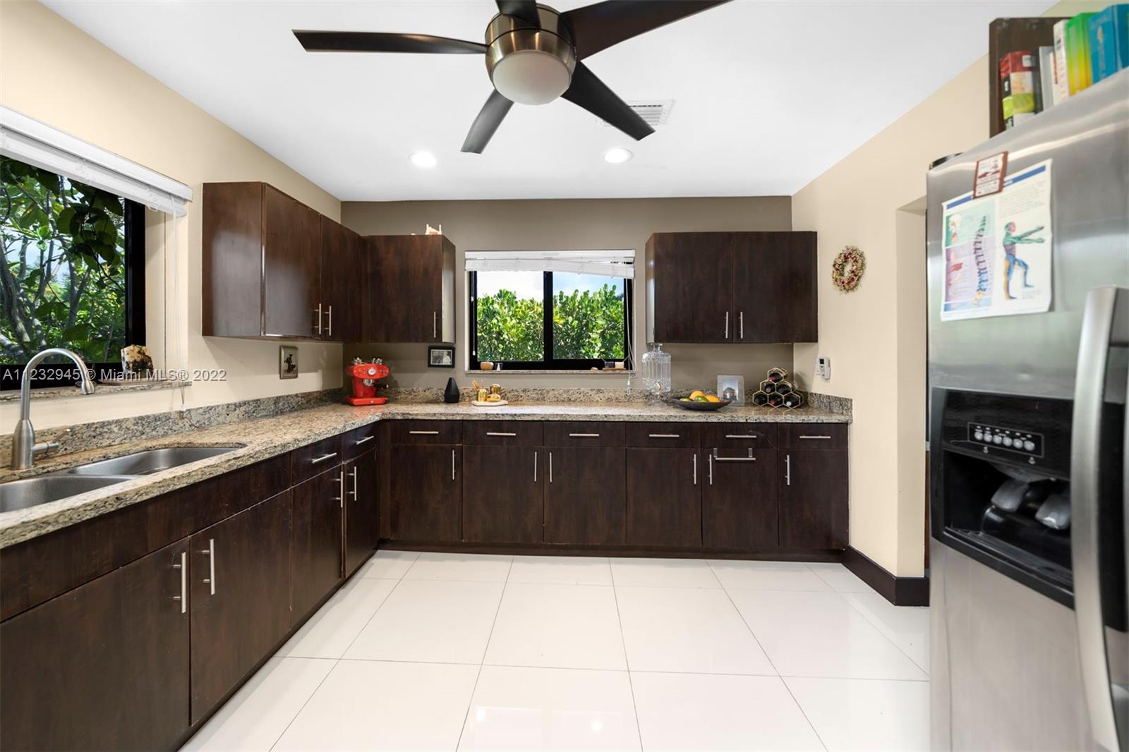 1598 Normandy Drive Miami Beach, FL 33141 - Photo 20 of 40 a kitchen with stainless steel appliances granite countertop a sink counter space cabinets and a large window