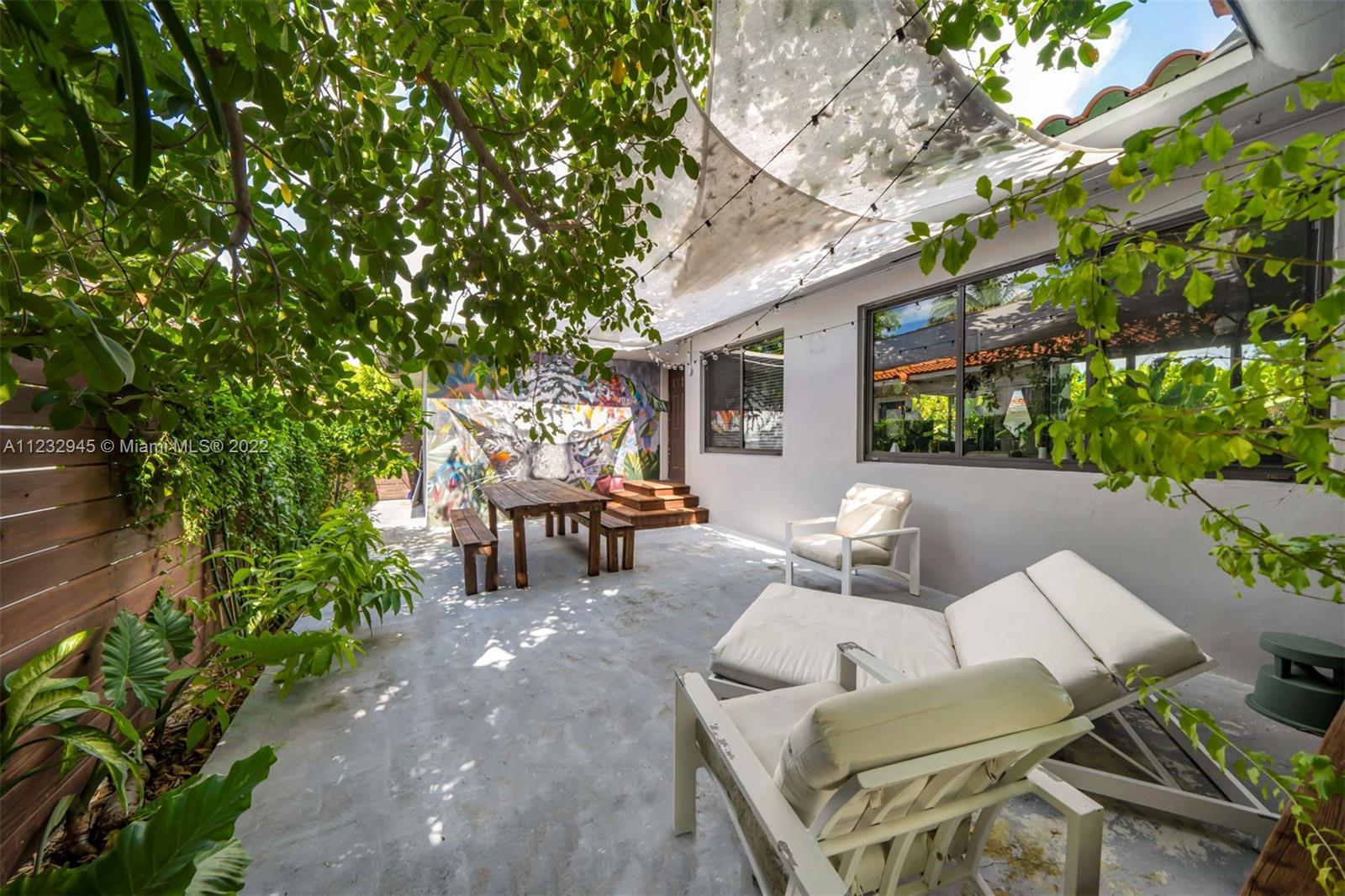 1598 Normandy Drive Miami Beach, FL 33141 - Photo 2 of 40 a view of a patio with table and chairs and potted plants