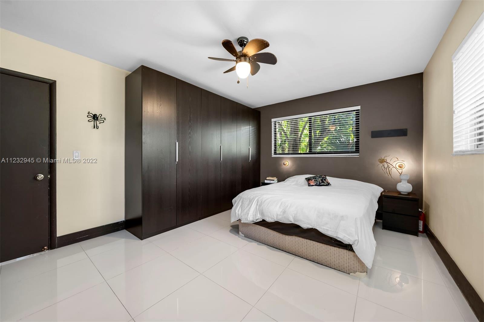 1598 Normandy Drive Miami Beach, FL 33141 - Photo 24 of 40 a bedroom with a large bed and a chandelier