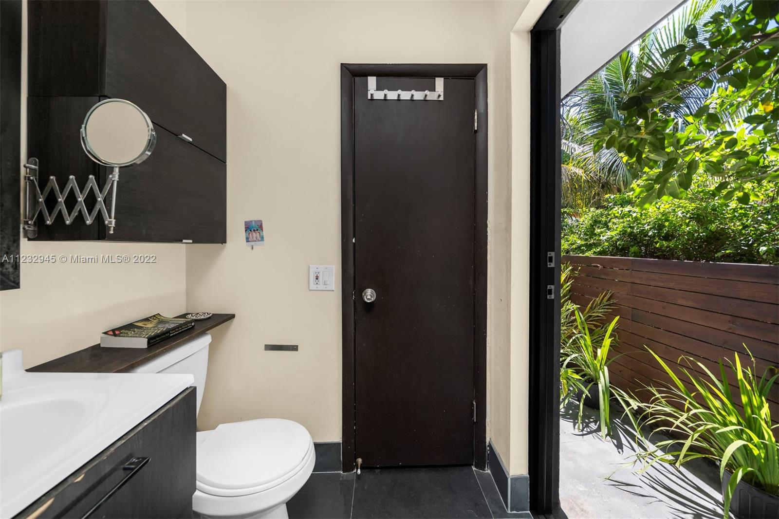1598 Normandy Drive Miami Beach, FL 33141 - Photo 29 of 40 a bathroom with a toilet a sink and mirror