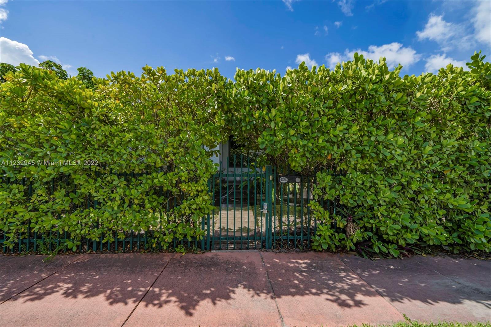 1598 Normandy Drive Miami Beach, FL 33141 - Photo 33 of 40 a view of a yard with plants and a bench