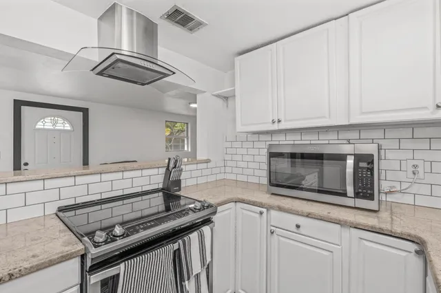 a kitchen with stainless steel appliances granite countertop a stove and a microwave