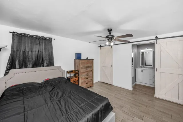 a bedroom with a bed dresser and a large window