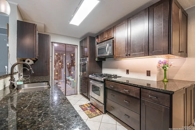 a kitchen with granite countertop stainless steel appliances and wooden cabinets