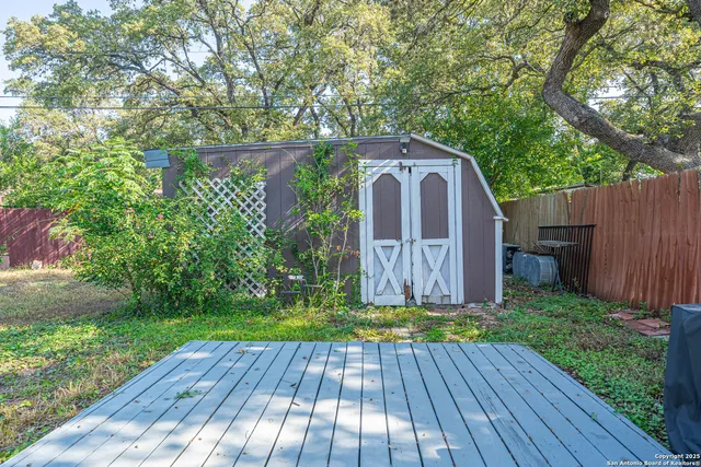 a view of backyard with a garden and wooden fence